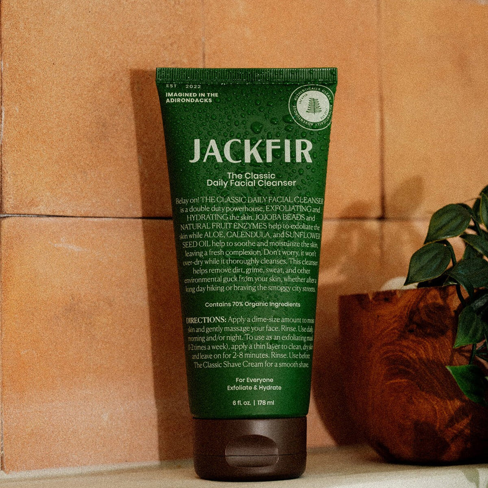 Jackfir Classic Daily Facial Cleanser green tube standing upright with brown cap beside potted plant