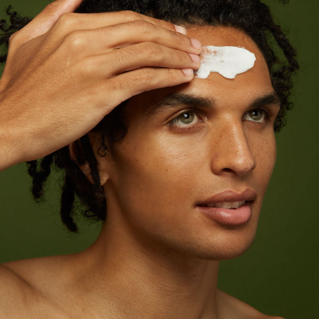 Man applying white Jackfir Classic Daily Facial Cleanser cream to forehead with hand