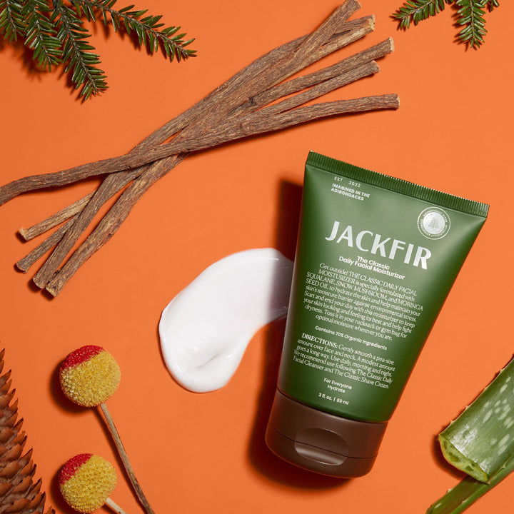 Jackfir Classic Daily Facial Moisturizer green tube with white cream dollop surrounded by twigs, pine branches and aloe