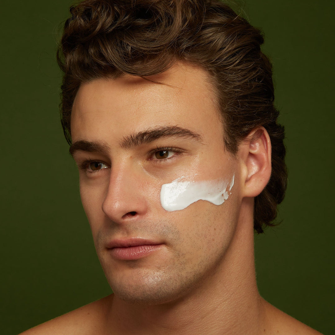 Man with white cream swipe of Jackfir Classic Daily Facial Moisturizer on right cheekbone