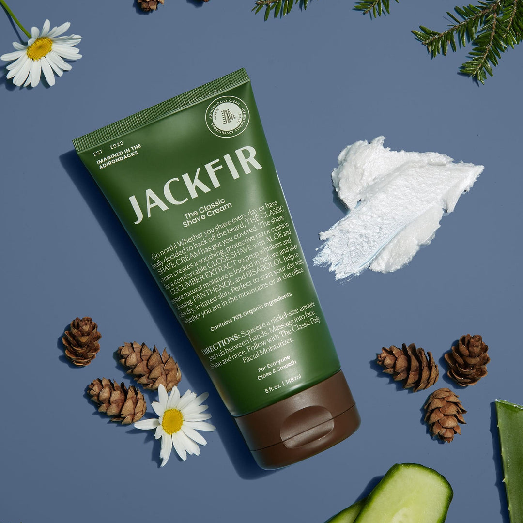 Jackfir Classic Shave Cream green tube with white cream smear surrounded by pinecones, daisies, and fir branches