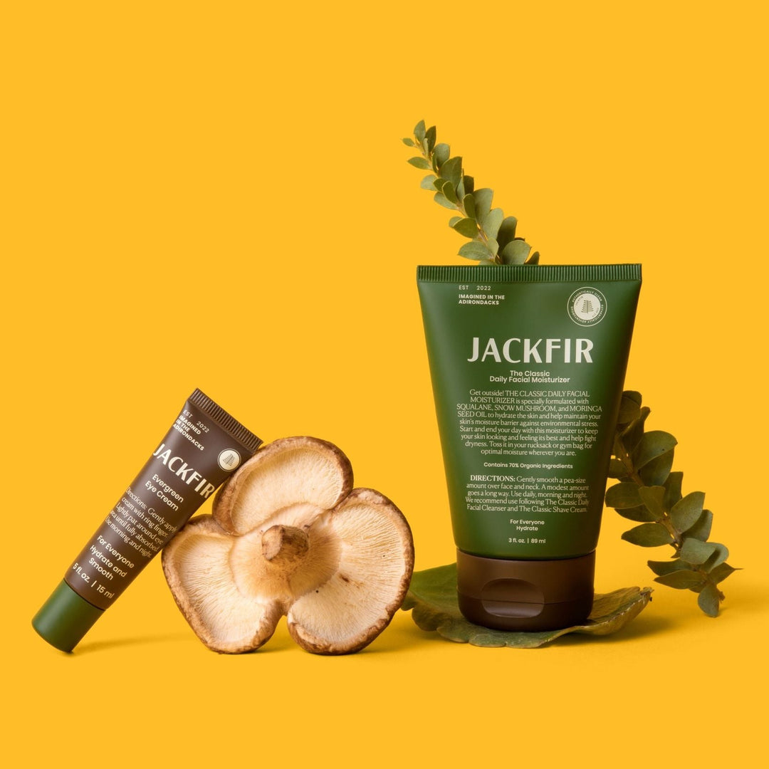 Jackfir Moisturizer + Eye Cream Duo standing with sliced mushrooms and eucalyptus leaves as props