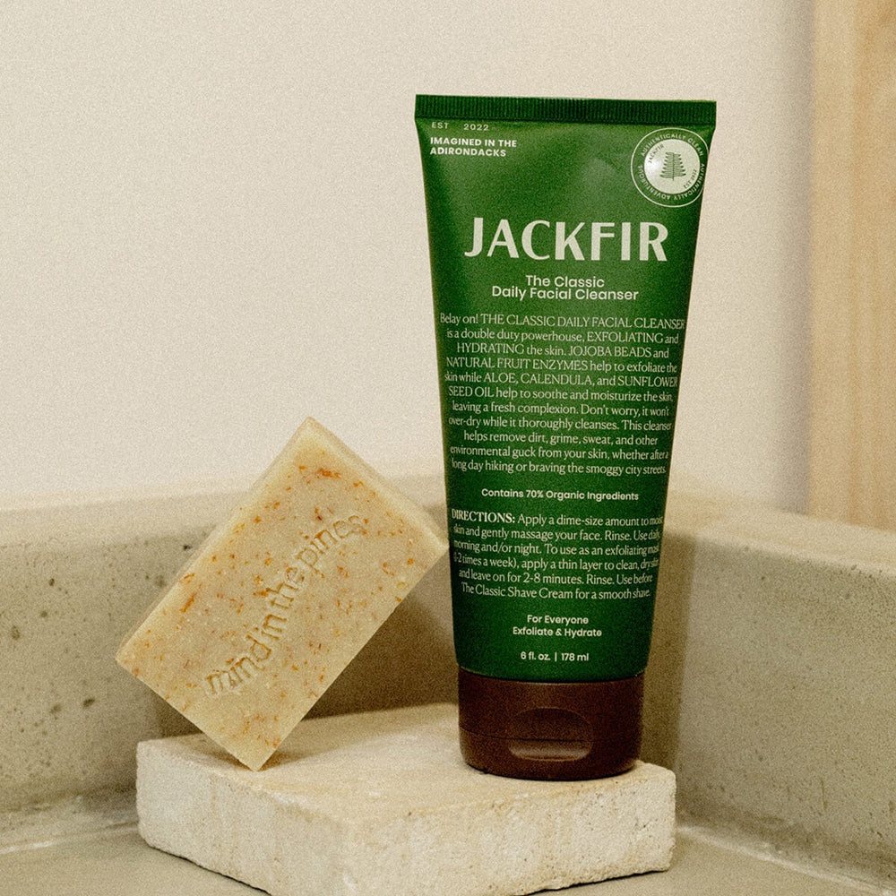 Jackfir The Exfoliating Duo green tube and beige exfoliating bar soap propped on stone blocks